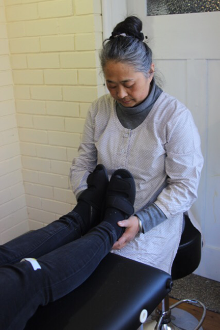 Biomagnetism practitioner holding ankles of a patient